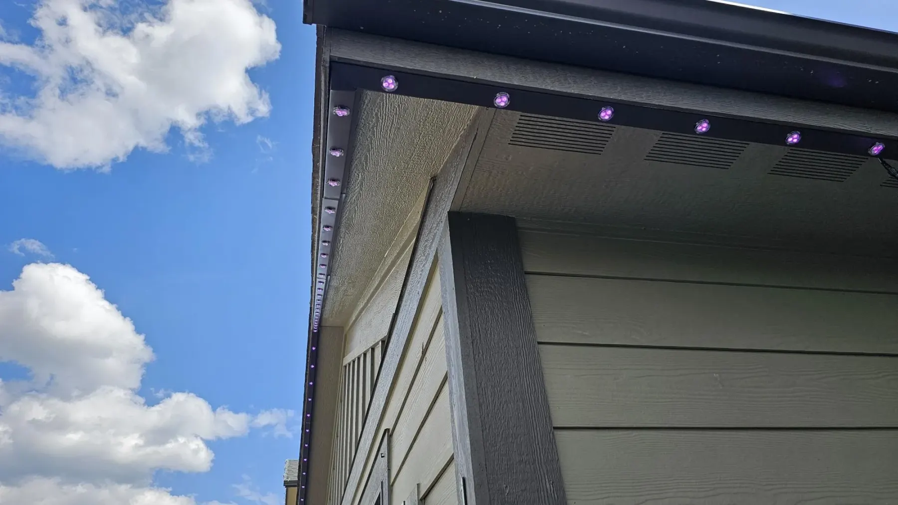 Aluminum lighting track installed flush along a soffit in daylight
